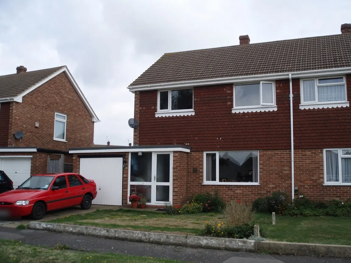 Semi-detached house with white gutters and downpipe